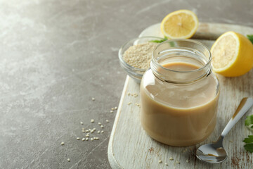 Concept of tasty food with tahini sauce on beige textured background