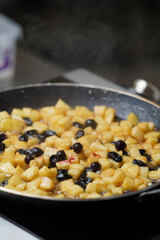 Frying apple with cinnamon and raisins for pancakes