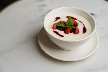 Semolina porridge with strawberries on a white table