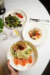 Caesar salad with salmon fish on white bowl