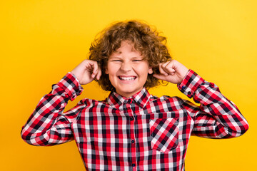 Photo of yell orange wavy hairdo teen boy close ears wear red checkered shirt isolated on yellow color background
