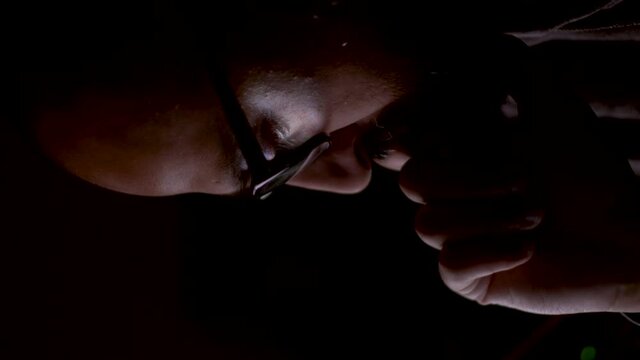 A close up vertical video of an Indian man in a deep dark psychological space, his anxiety and depression sending his mind down a deep black hole as he rocks back and forth in thought