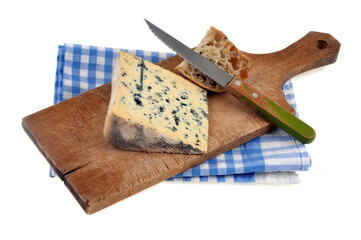 Bleu des Causses sur une planche à découper avec un couteau posé sur un torchon sur fond blanc