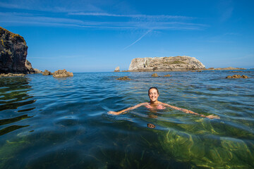 Happy woman swimming in the sea of an idyllic beach