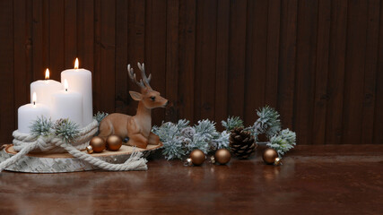 Weihnachtshintergrund: Dekoration weiße Kerzen mit einem Hirsch und Weihnachtskugeln.