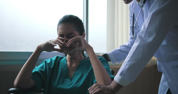 At the hospital, an overworked young woman in a wheelchair closes her eyes and sobs. The doctor reassured her and spoke with her to see if she needed any help.