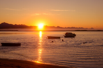Golden Sunrise over the lagoon  with the distant view of mountains and fishermen boats