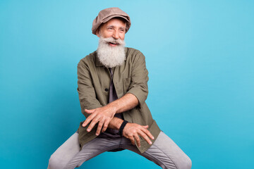 Portrait of attractive cheery funny grey-haired middle-aged man dancing having fun isolated over bright blue color background