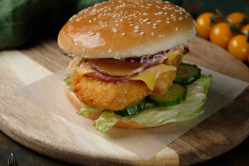 burger with chicken on a wooden board