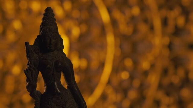 Statue of Parvati goddess, wife of Shiva, Hinduism religion. Turntable, light fading in, turning on beam.