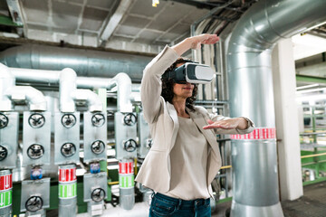 Female expert gesturing while using virtual reality headset in industry