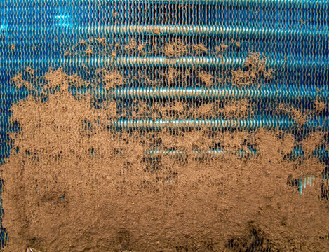 Dust-clogged aluminum radiator grill of a car. Clogged cooling system. Refrigerator repair. Cooling radiator. Car service. Repair of air conditioners. Industrial equipment.