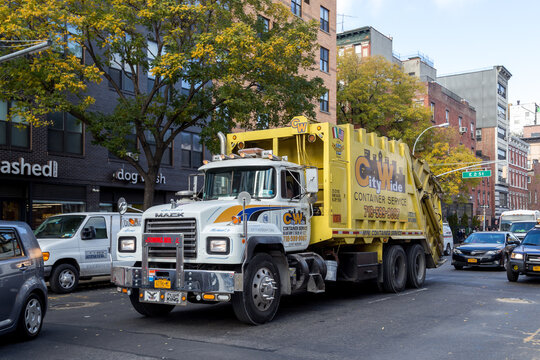 New York, United States of America - November 19, 2016: A big yellow garbage truck in the streets of Manhattan