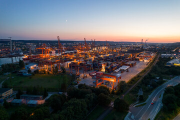 Port of Gdynia at night. Night view of the port in Gdynia from a drone. Sea transport, containers and night-light container ships on the Baltic Sea.