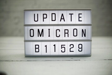 Update Omicron B11529 alphabet letter in Lightbox on wooden and white brick background