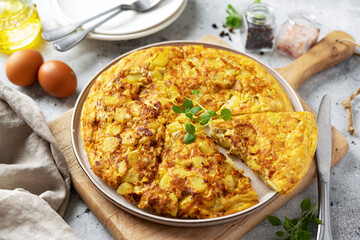 Frittata or potato pie in a ceramic plate on a light culinary background. Traditional Italian delicious homemade egg dish on the kitchen table	