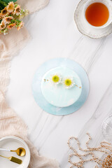 Trendy mousse cake with mirror glaze decorated. Modern european desserts at white marmer stone background.