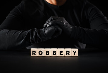 Theft, crime, robbery or burglary concept. The word robbery written on wooden blocks with a thief...