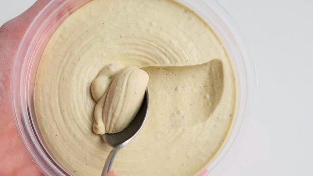 Eating traditional hummus with a spoon, close-up.