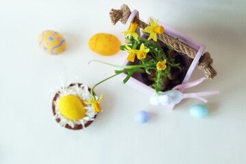 Easter eggs, spring plants, toy hares on a light background, home interior decoration for the holiday 