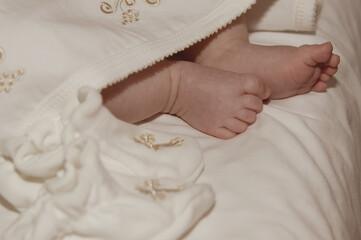 Baby's legs in the church at the baptism ceremony. Religion. Close-up.