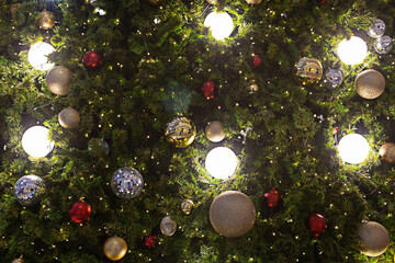 Obraz na płótnie Canvas Closeup of balls on Christmas tree. Bokeh garlands in background. New year concept.