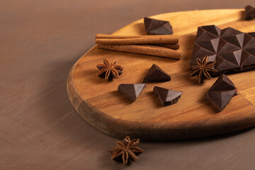 Dark bitter chocolate is broken into pieces. Decorated with cinnamon sticks.