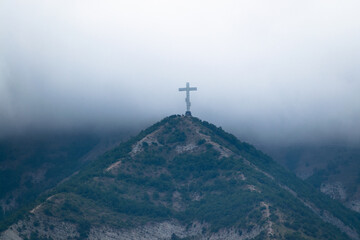Cross on the mountain and white clouds.