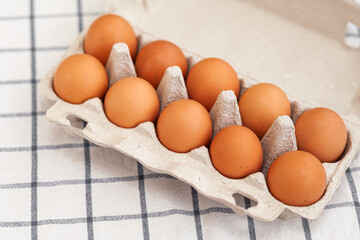 A few brown eggs among the cells of a large cardboard bag, a chicken egg as a valuable nutritious product, a tray for carrying and storing fragile eggs. A full package of eggs, an important food item