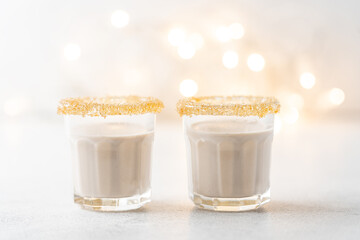 Eggnog with cinnamon and nutmeg for winter holidays. Christmas traditional eggnog in glasses on white background with garland