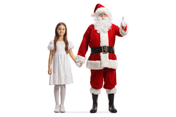 Full length portrait of santa claus showing thumbs up and holding hands with a girl in a white dress