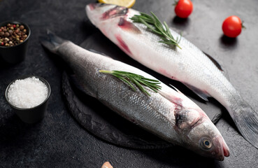 raw sea bass fish with spices on a stone background