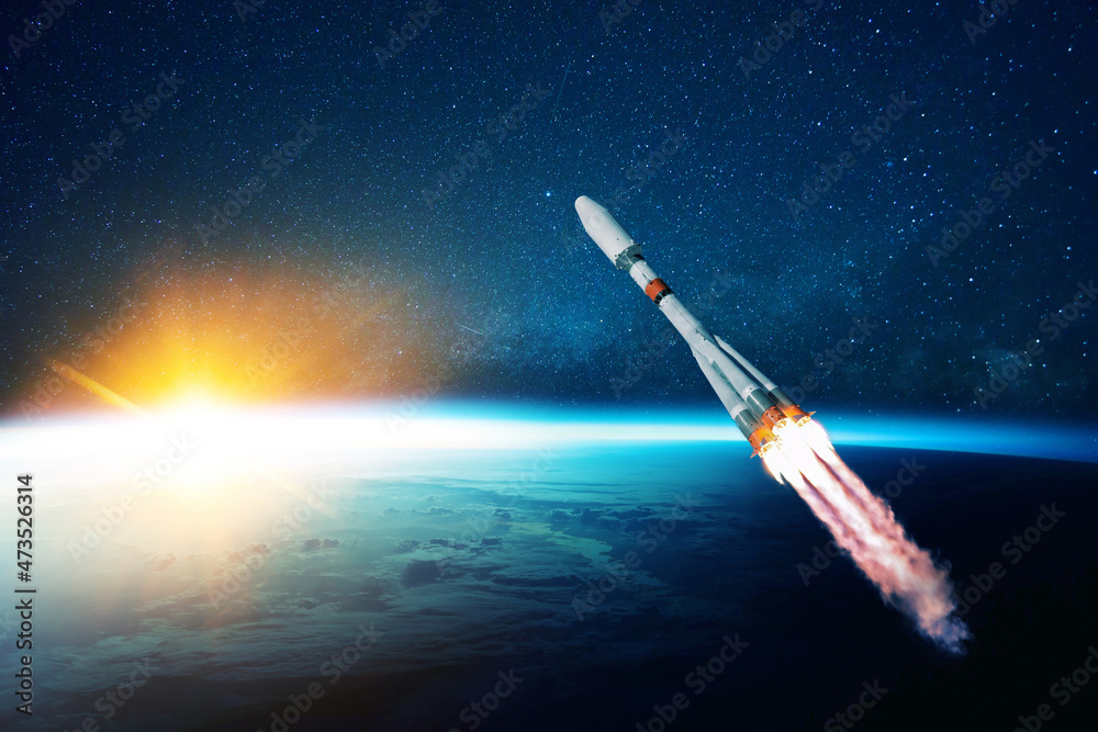 Wall mural space rocket flies in the starry sky over the amazing blue planet earth and yellow sunset. spaceship