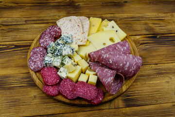 Antipasti platter with assortment of italian salami and cheese on wooden table