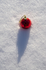 Red ball with golden rope on the snow.