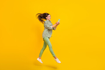 Fototapeta na wymiar Full body profile side photo of young woman use smartphone app download jump walk isolated over yellow color background