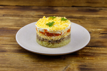 Traditional russian salad Mimosa on wooden table