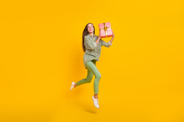 Fototapeta na wymiar Full body profile side photo of young cheerful girl jumper energetic receive present isolated over yellow color background