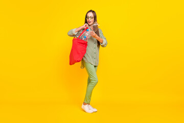 Fototapeta na wymiar Full length photo of young pretty woman pick used garbage save the planet isolated over yellow color background