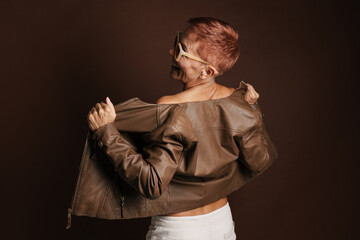 Senior ginger woman smiling while posing in leather jacket