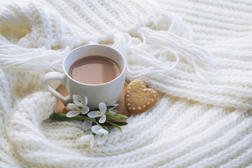 white scarf, a cup of cocoa, a bouquet of snowdrops, a gift, a heart-shaped cookie. romantic background, valentine's day card. congratulations on March 8. cozy scene. with love.