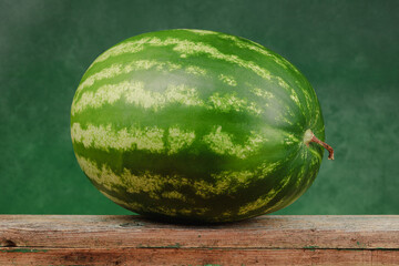 Watermelon on a wooden boards and green marble wall. 