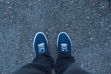 Blue sneakers and text on asphalt
