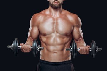 Fototapeta na wymiar Close up of muscular body and strong hands lifting heavy dumbbells isolated over black background