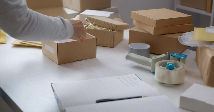 The warehouse worker packs the goods in a box for delivery by courier service.