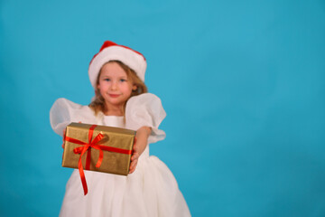 Selective focus gold box. Children gifts for Christmas and New Year. Girl background isolate place text isolate. serious beautiful preschool girl stand with gift in hands red bow. cute girl looks hair