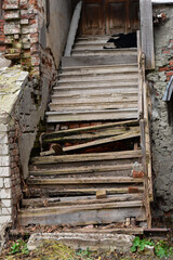 Fototapeta na wymiar Destroyed wooden staircase with broken railings.