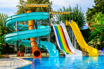 View on a swimming pool with turquoise clear water and water slide