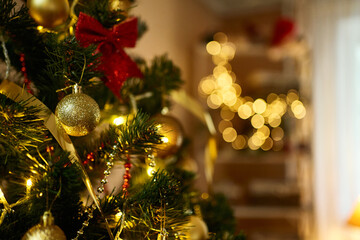 Close up decorated Christmas tree with golden balls, xmas toys, lights, glowing lamps in living room. Bokeh garlands on background