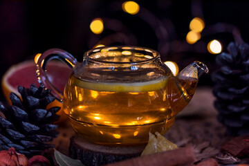 A teapot with herbal tea on a table with bokeh effect lights, close up, still life photography, christmas spirits